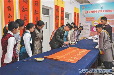 11月6日，信息搭救戎行工程大学通讯士官学校“红岩雪鹰”宣传队队员在重庆西藏中学宣讲后，与师生一王人参与学校书道社团步履。 谌世鑫摄